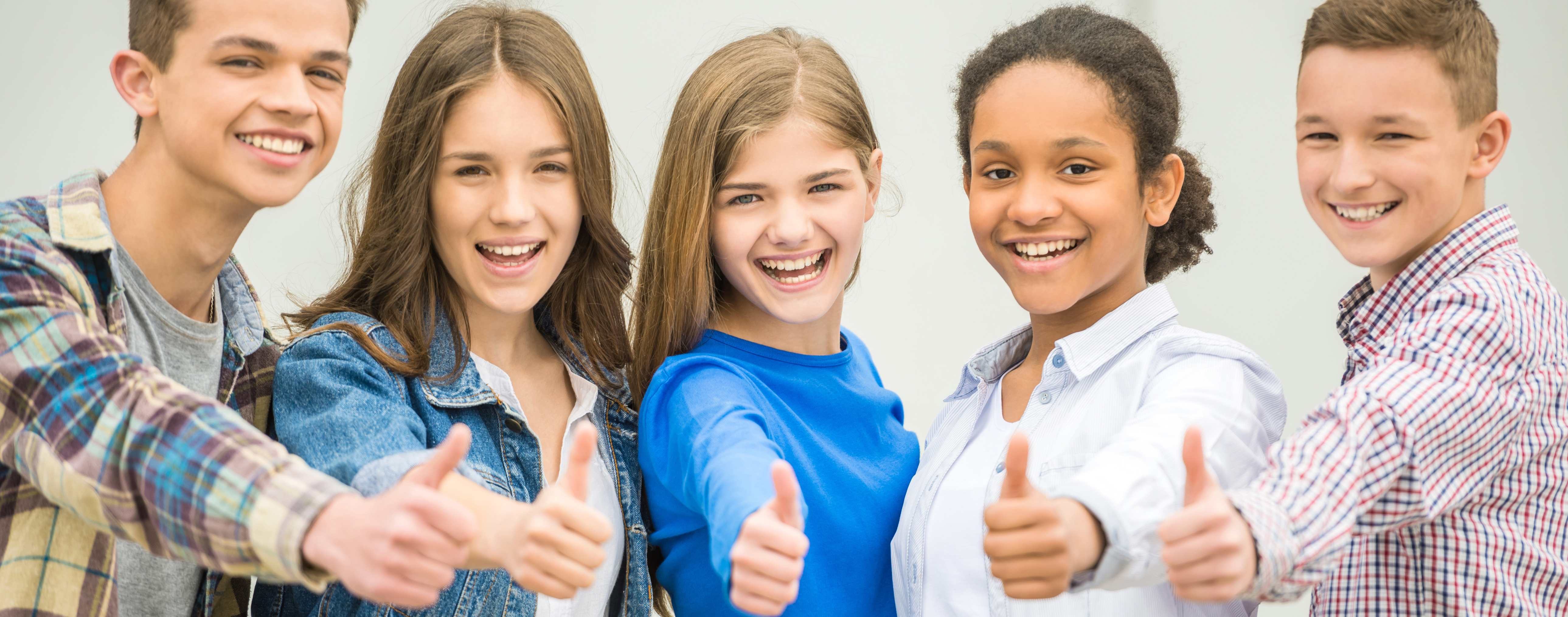 Group of teenagers smiling giving thumbs up