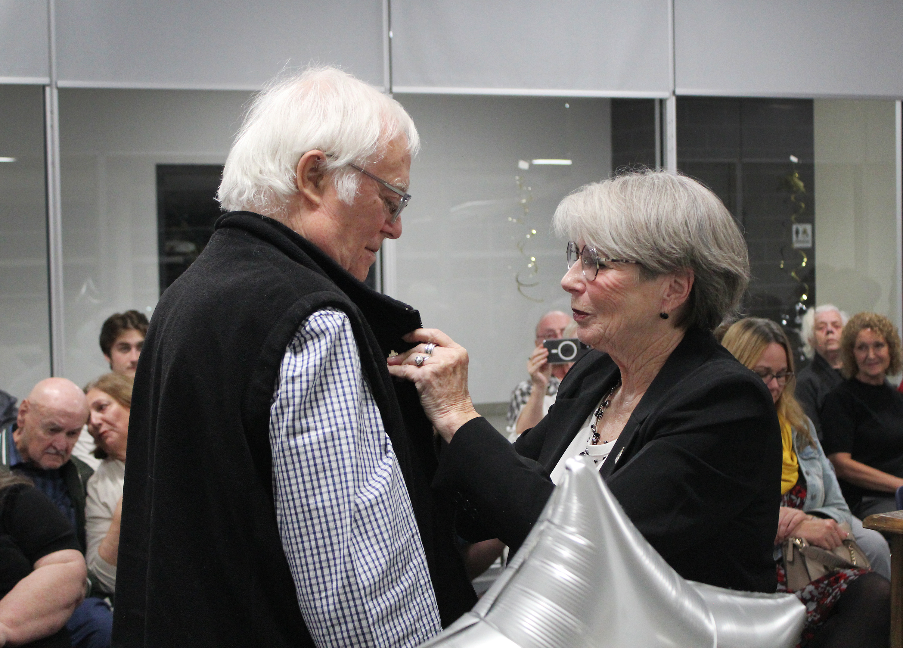 Dennis accepts award from Mayor Cheryl Ganann on behalf of his late partner Lucien Rene